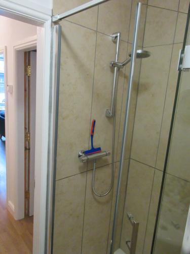 eine Dusche mit einer Glastür mit einer Zahnbürste in der Unterkunft WEE NEUK in Cellardyke