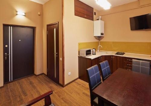 a kitchen with a table and a dining room at Apartment on Lychakivska in Lviv