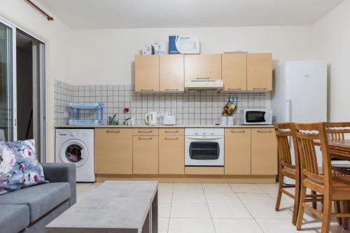 een woonkamer met een bank en een keuken bij EURO CARISSA FLAT 101 in Larnaka