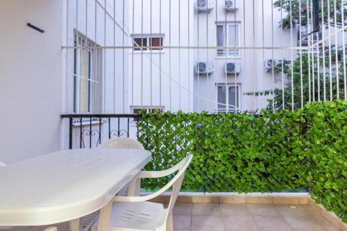una mesa blanca y sillas en un balcón con un edificio en EURO CARISSA FLAT 101, en Lárnaca