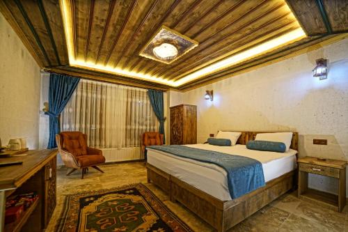 a bedroom with a bed and a desk and a chair at Termessos Hotel in Goreme