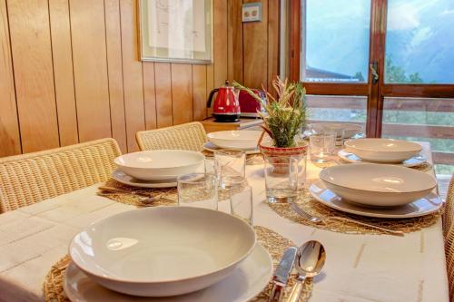 uma mesa com pratos brancos e tigelas em Marcolski Home 2 em Breuil-Cervinia