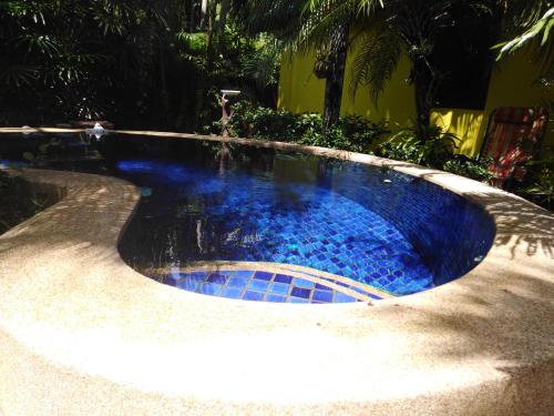 uma piscina com água azul num quintal em Sanuk Bungalow em Khao Lak