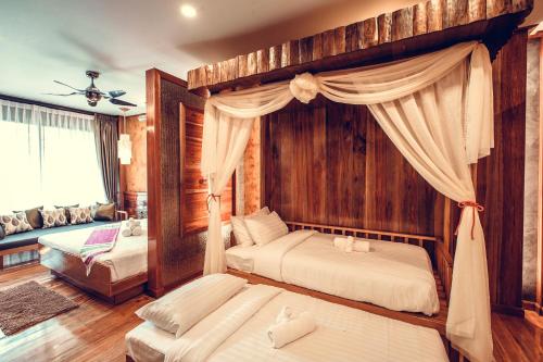 a bedroom with two beds and a canopy bed at Andalay Beach Resort Koh Libong in Ko Libong