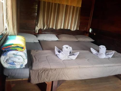 two beds in a room with towels on them at Maan Mork Khao Kho in Khao Kho
