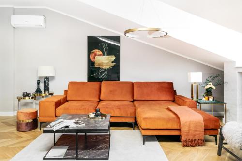 a living room with a couch and a table at Penthouse Orzeszkowa by LoftAffair in Krakow