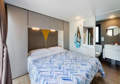 a bedroom with a large bed and a bathroom at Camping Village Du Parc in Lazise