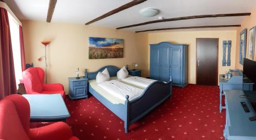 sypialnia z łóżkiem i czerwonym dywanem w obiekcie Der Mühlenhof w Büsum