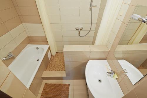 La salle de bains est pourvue d'une baignoire, de toilettes et d'un lavabo. dans l'établissement Apartment on Lychakivska, à Lviv