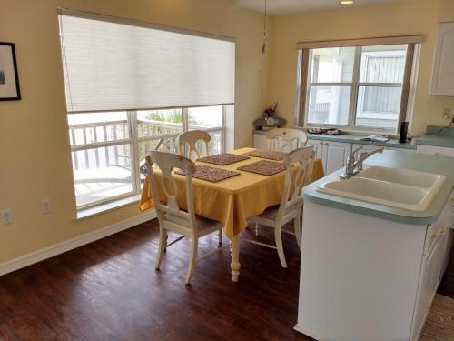 a kitchen with a table with chairs and a sink at Seahorse Landing #503 Gulf Front Vacation Condo in Cedar Key