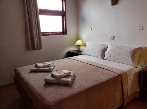 1 dormitorio con 1 cama con 2 toallas en Cabañas de las Mellizas, en Villa Carlos Paz