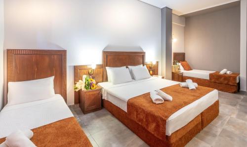 a hotel room with two beds with towels at Paralia Beach Boutique Hotel in Paralia Katerinis