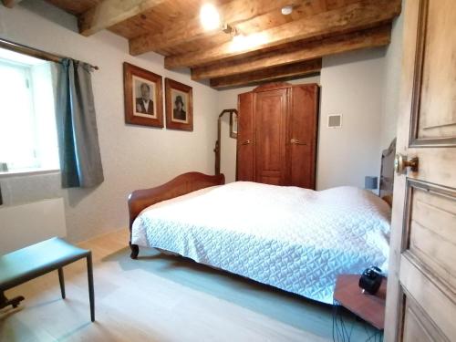 een slaapkamer met een bed en een houten kast bij Vakantiehuis Le Vieux Tilleul in Pionsat