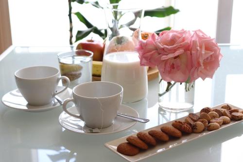 a table with two cups and a tray of pastries at CONSTITUCIÓN SUITE CONFORT I in Granada