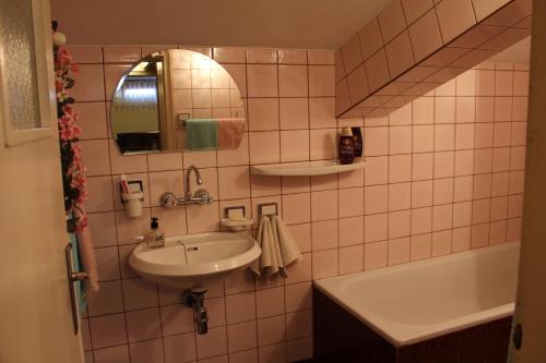 Studio Pleven Center في بليفين: حمام مع حوض ومرآة وحوض استحمام