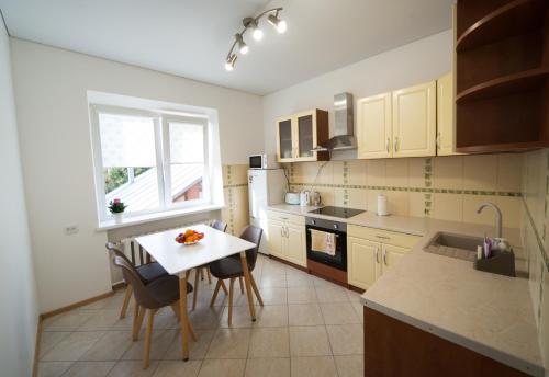 Una cocina con mesa y sillas y una ventana. en Petro delux apartments center, en Kaunas