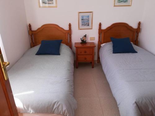 a bedroom with two beds and a night stand at Casa El Salao in Caleta de Sebo