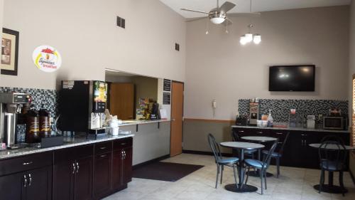 a restaurant with a bar with chairs and a table at Super 8 by Wyndham Pella in Pella