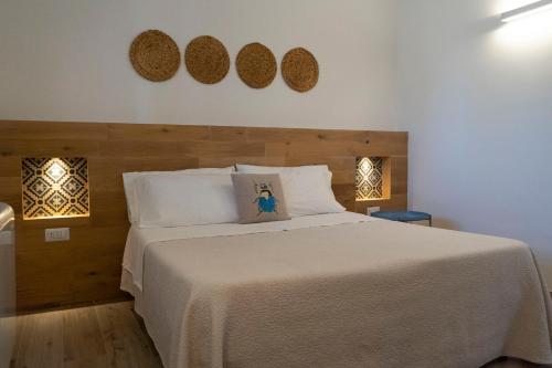 a bedroom with a large white bed with two plates on the wall at Corallo Country House in Noci