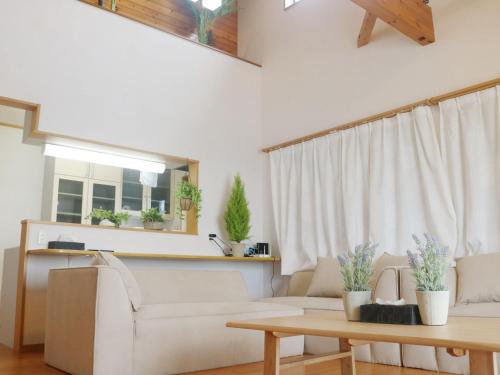 a living room with a couch and a table at Ocean Villa Okinoerabu in Wadomari