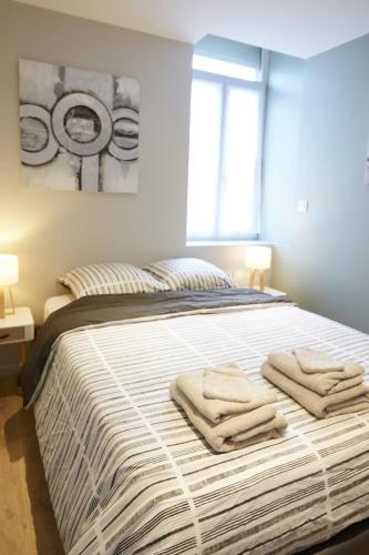 une chambre avec un lit avec des serviettes dessus dans l'établissement LocationsTourcoing - Le Carnot, à Tourcoing