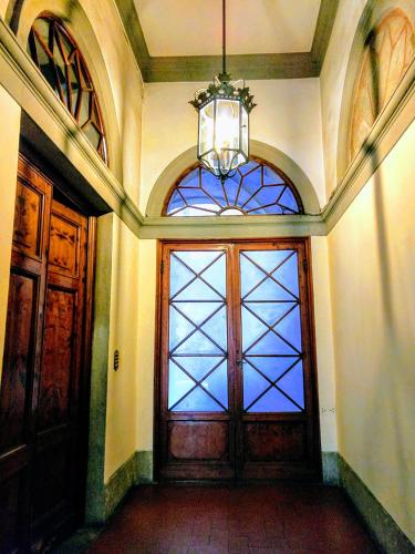 a large wooden door with a window and a chandelier at Palazzo Martellini Residenza d'epoca in Florence