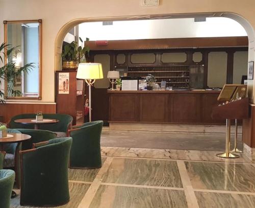 um restaurante com mesas e cadeiras e um piano em Hotel Milano em Trieste