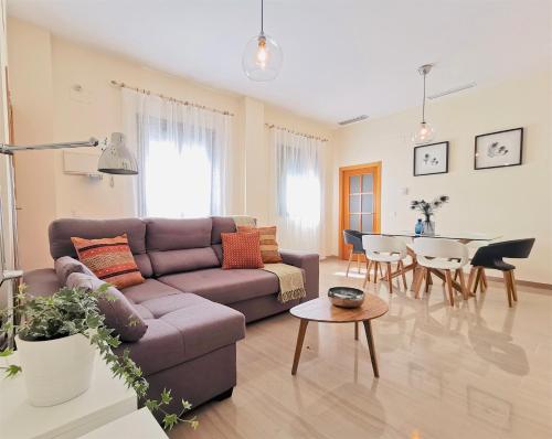 salon z kanapą i stołem w obiekcie Teodosio Apartment FREE PARKING & CENTRAL AC w Sewilli