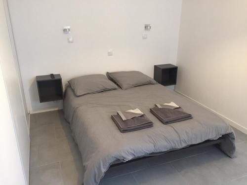 a bedroom with a bed with two towels and two speakers at Maison avec Jardin/Piscine - Quartier résidentiel in Marseille