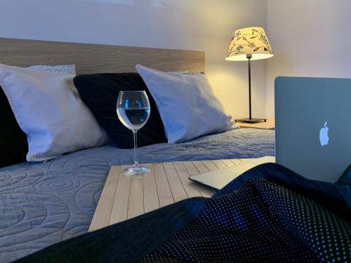 a glass of wine sitting on a table next to a bed at Marszałka 28 in Jelenia Góra