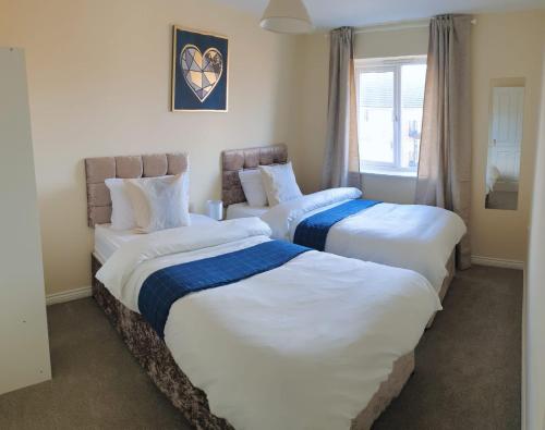 a room with three beds with white sheets and a window at Seymour Road - Parking for van - Contractors only in Oldbury