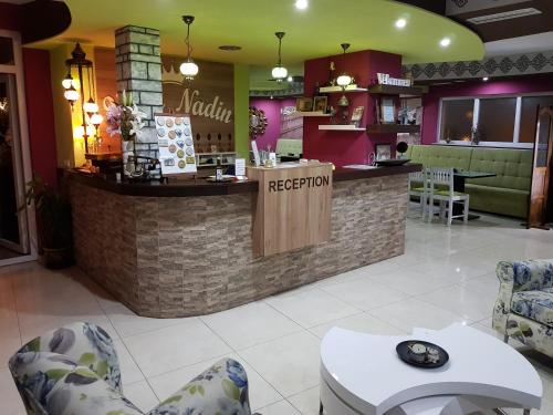 a restaurant with a counter and chairs in a room at Hotel Villa Nadin in Mostar