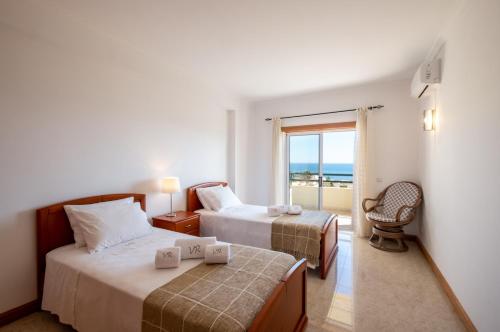 a hotel room with two beds and a balcony at VR Galé Mar in Albufeira