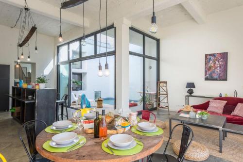 a dining room with a table and chairs and a couch at Domaine la Clausade in Mauguio