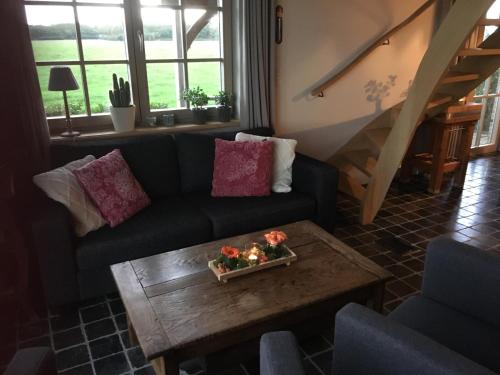 a living room with a couch and a coffee table at 't Ligt ter Velde, oase van rust, sauna, directie Brugge in Lichtervelde
