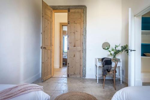 a bedroom with a door and a table with a chair at Domaine la Clausade in Mauguio