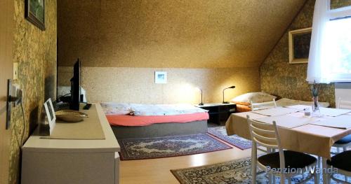 um quarto com uma cama e uma mesa e um quarto em Penzion Wanda em Bohumín