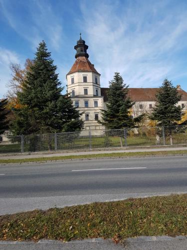 a building with a tower on the side of a road at Ferienwohnung am Thayatalradweg in Schwarzenau