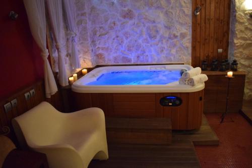 a bath tub in a room with a chair at Hagiati Anastasiou Hotel & Spa in Naousa