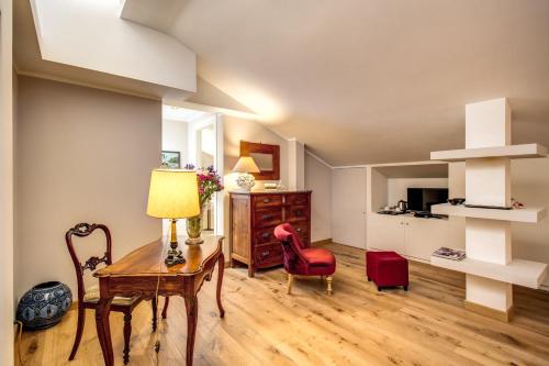 a living room with a table and a red chair at La Gaura Guest House in Casal Palocco