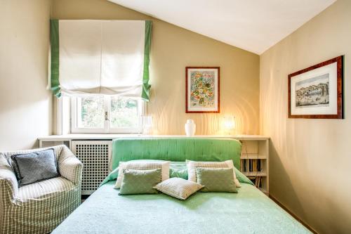 a bedroom with a green bed and a chair at La Gaura Guest House in Casal Palocco