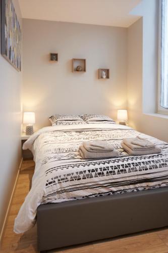 une chambre avec un lit avec deux lampes dessus dans l'établissement LocationsTourcoing- Le Valmy, à Tourcoing