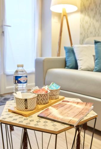 - une table basse avec de la nourriture et une bouteille d'eau dans l'établissement LocationsTourcoing- Le Valmy, à Tourcoing