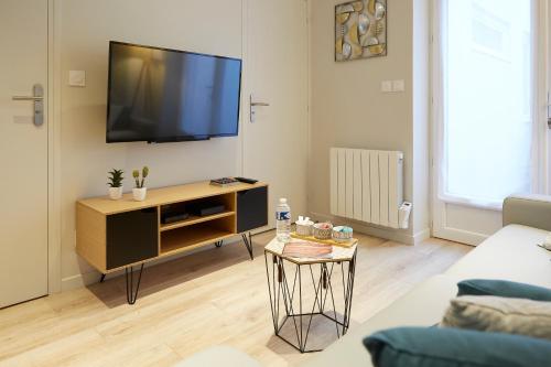 a living room with a flat screen tv on a wall at LocationsTourcoing- Le Valmy in Tourcoing