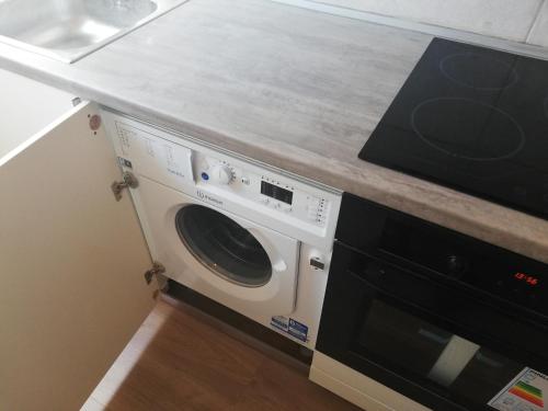 Una lavadora y secadora bajo una barra en la cocina en Central en Patras
