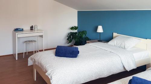 1 dormitorio con cama blanca y pared azul en Apartman 13 en Križevci