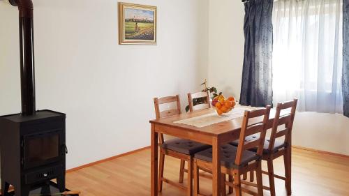 a dining room table with four chairs and a stove at Apartman 13 in Križevci