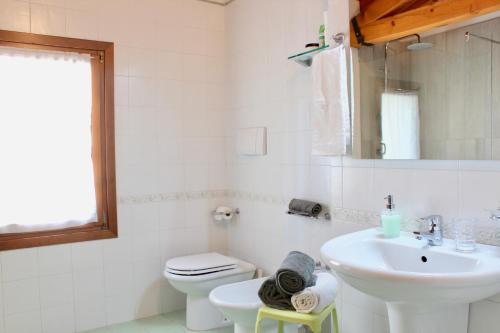 Baño blanco con lavabo y aseo en Casetta Carmine, en Asolo