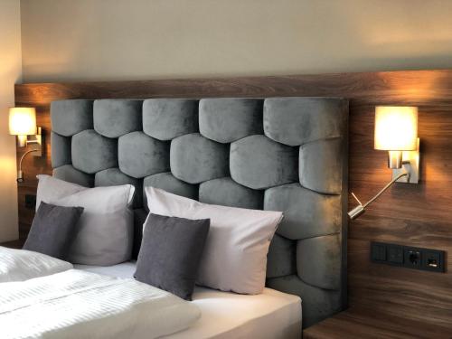 a bedroom with a bed with a stone headboard at Intergroup Business & Design Hotel Ingolstadt in Kösching