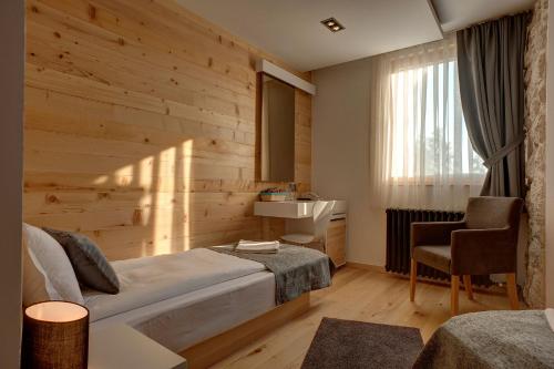 a bedroom with a bed and a desk and a sink at Hotel Žabljak in Žabljak